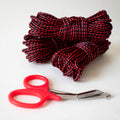 Red and black 1/4-inch solid braid MFP bondage rope kit by Agreeable Agony, shown coiled and ready for use.