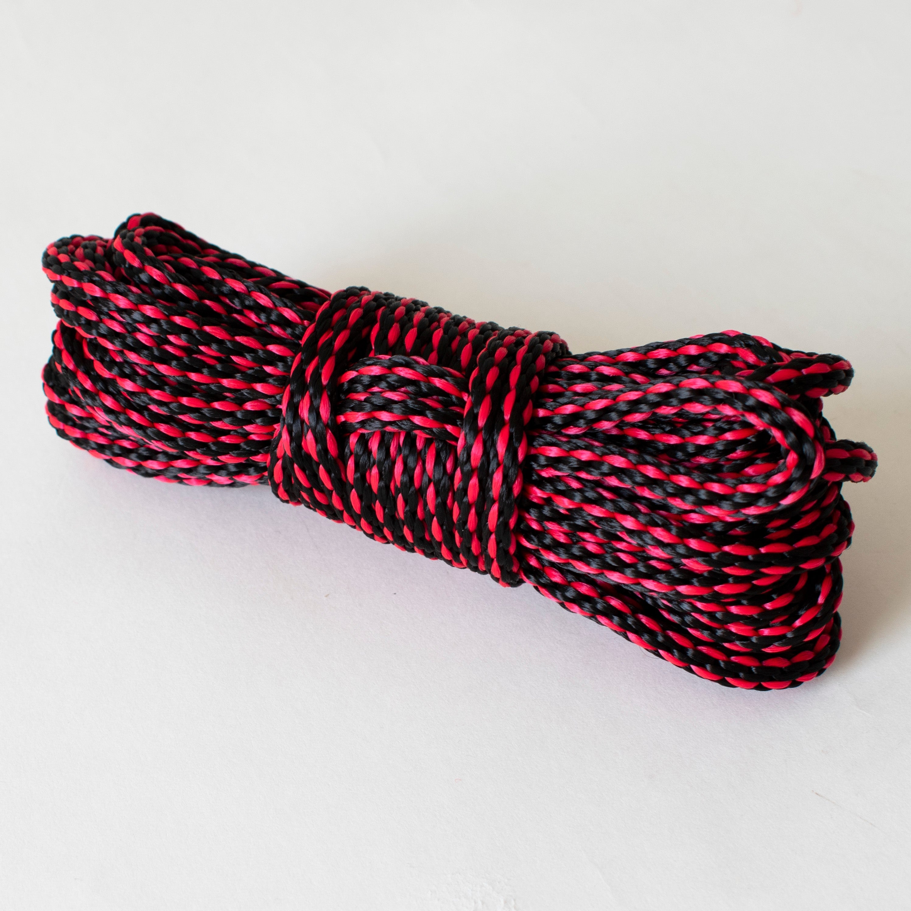 Red and black 6mm solid braid MFP rope from Agreeable Agony, ideal for bondage rope kits, shown in a close-up image.