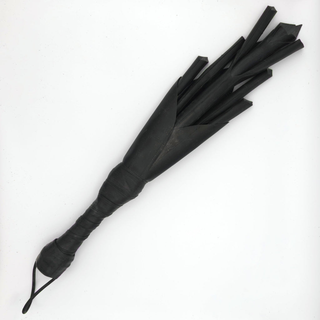 Agreeable Agony Petal Slapper rubber paddle with leather handle, flower design, used as a playful BDSM accessory.
